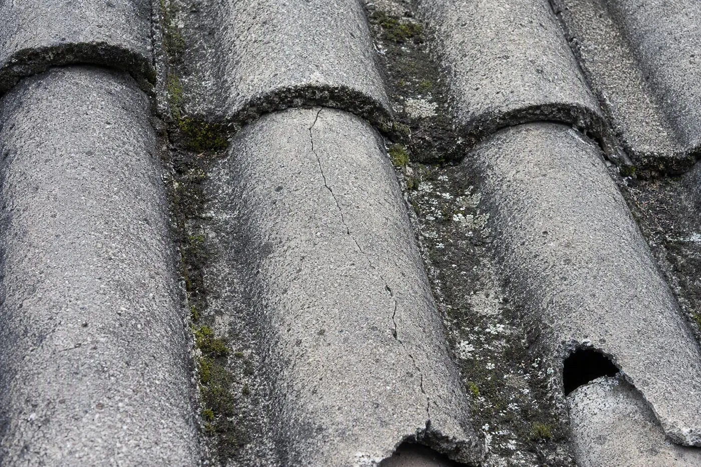 Cracked cement roof tiles being repaired